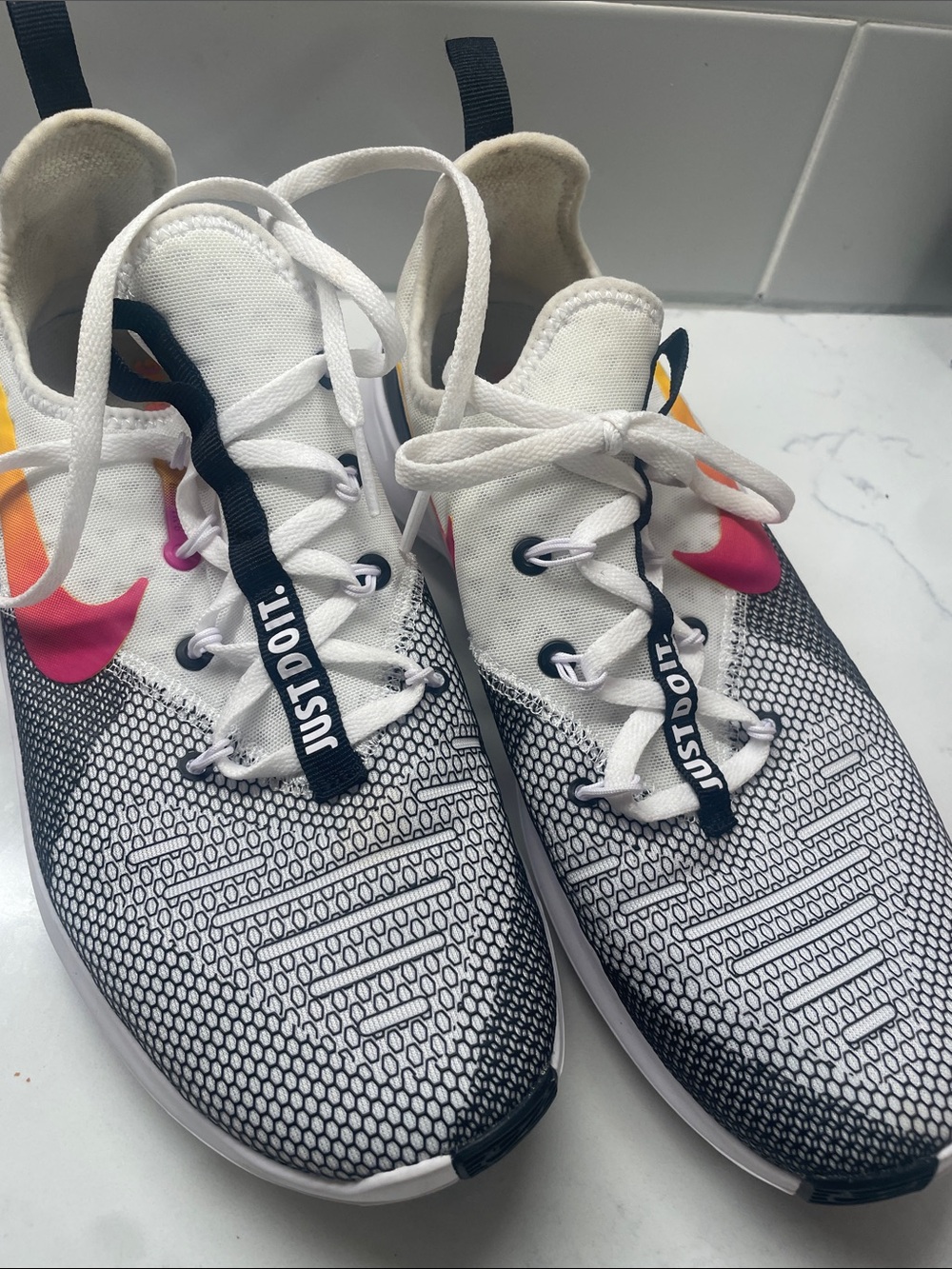Nike White Sneakers with Black Accents and Pink-Orange Swoosh